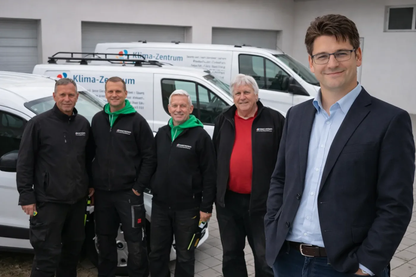 Ing. Christian Klaghofer mit seinem Serviceteam vor den Firmenfahrzeugen